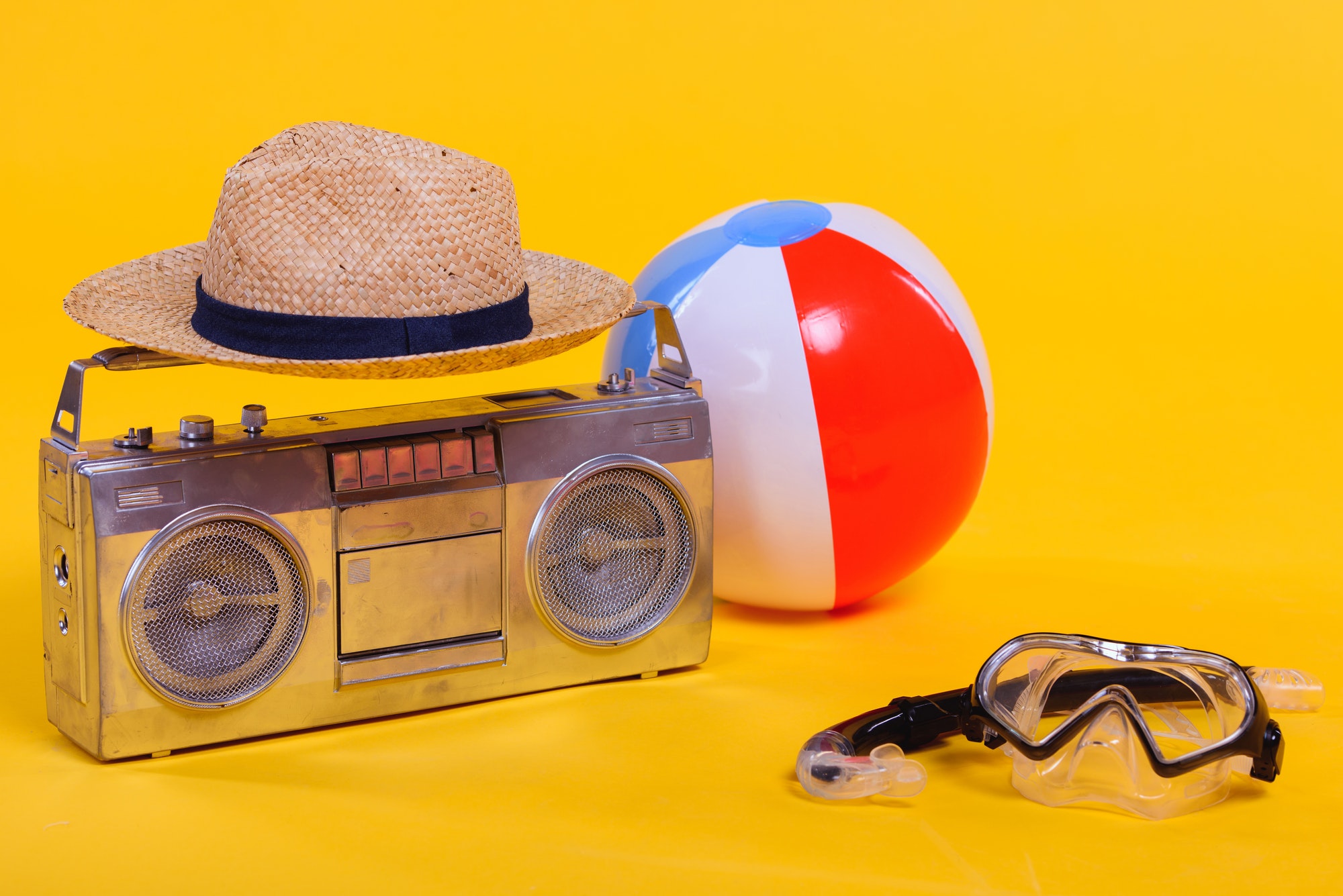tape recorder, hat, beach ball and snorkel with scuba mask isolated on yellow